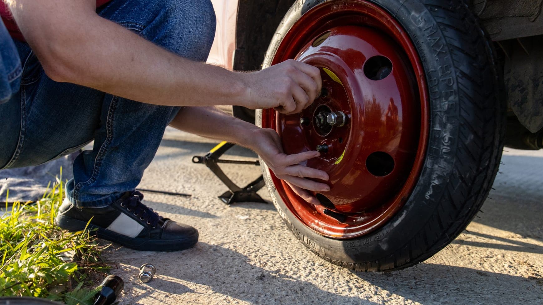 A Stranded Driver Putting on a Temp-Spare Tire